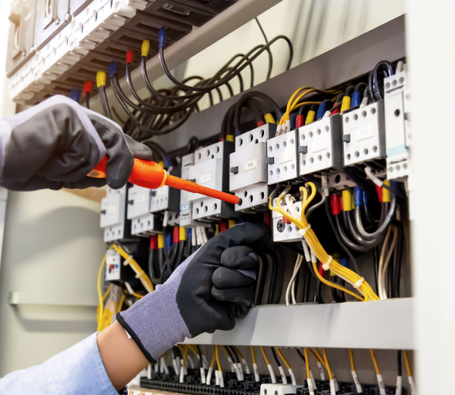 Electrician technician at work blocks the cable between the clamps of a socket in a residential electrical installation